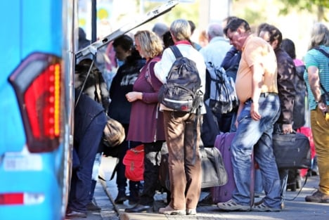 Passengers line up to get on the bus. Photo: DPA